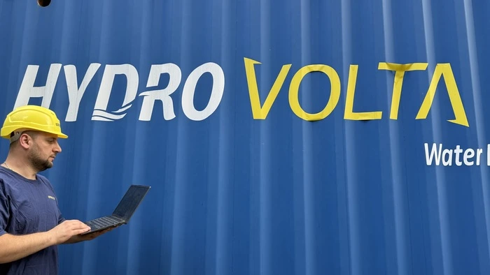 Worker on pc next to container